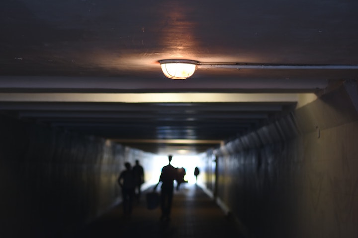 People walking down a dark hallway